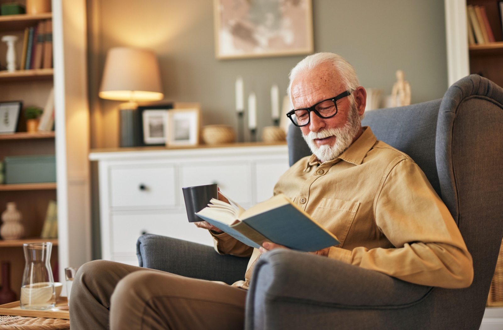 A senior enjoys a cup of tea and a book in the evening as they wind down for bed.