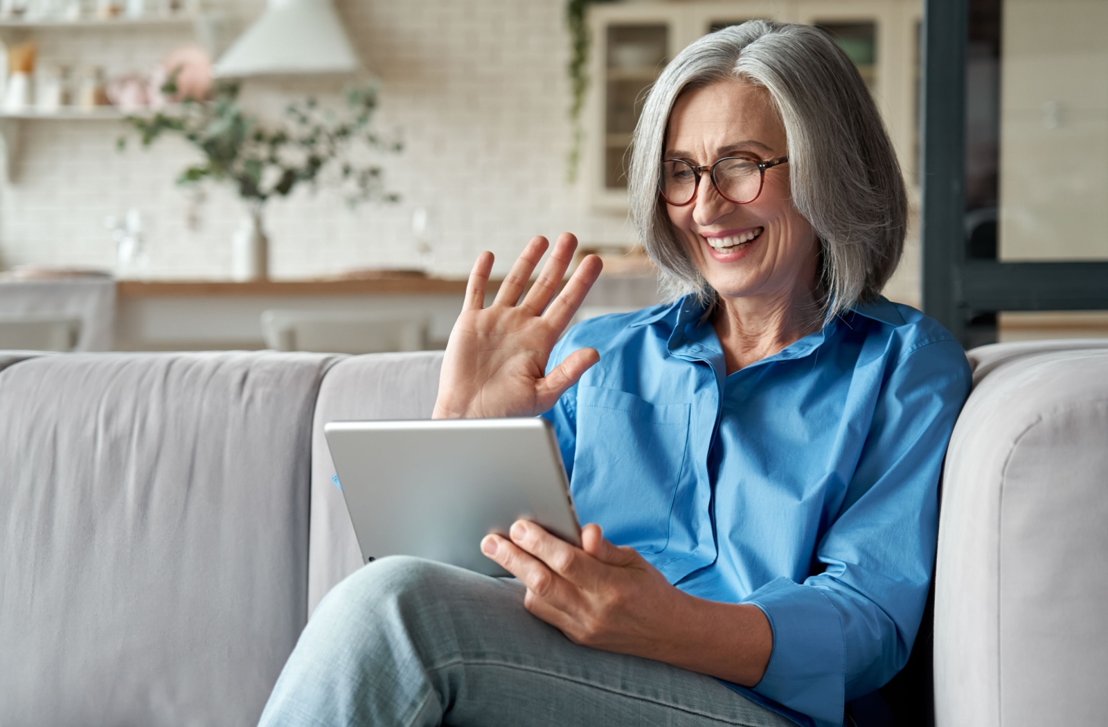 A senior connects with their loved ones with a video call app on their tablet.