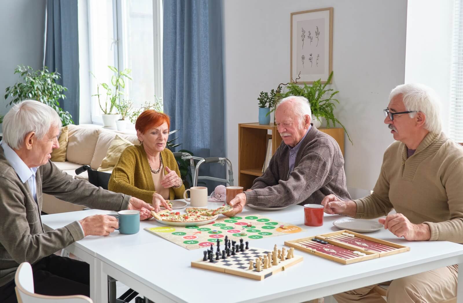 A group of happy seniors sitting around playing games and enjoying snacks together